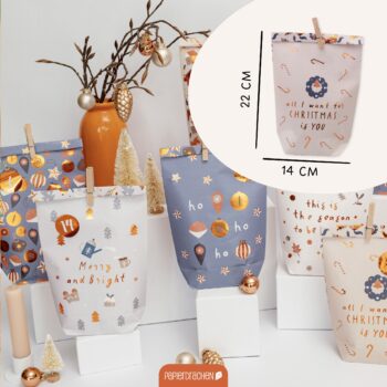 Verschiedene festliche Papiergeschenktüten mit Weihnachtsmotiven und Dekorationen in einer stilvollen Anordnung