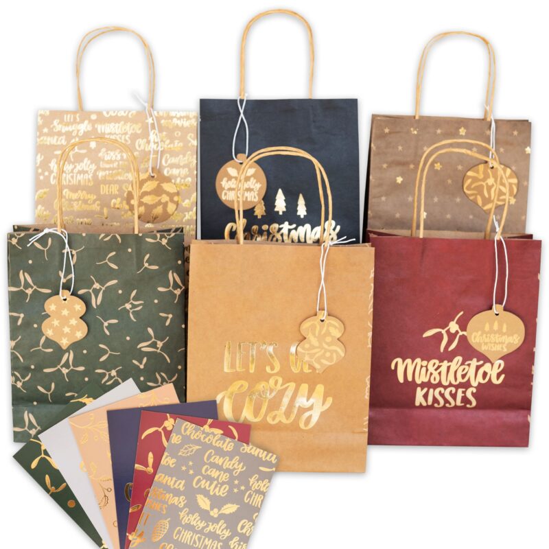 Verschiedene weihnachtliche Papiertüten und Geschenkanhänger mit goldenen festlichen Mustern und Schriftzügen wie Let's get cozy und Mistletoe Kisses