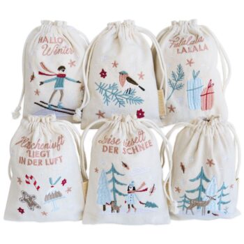 Sechs bestickte Stoffbeutel mit winterlichen Designs wie Skifahrer Schneemann und Tannenbäume